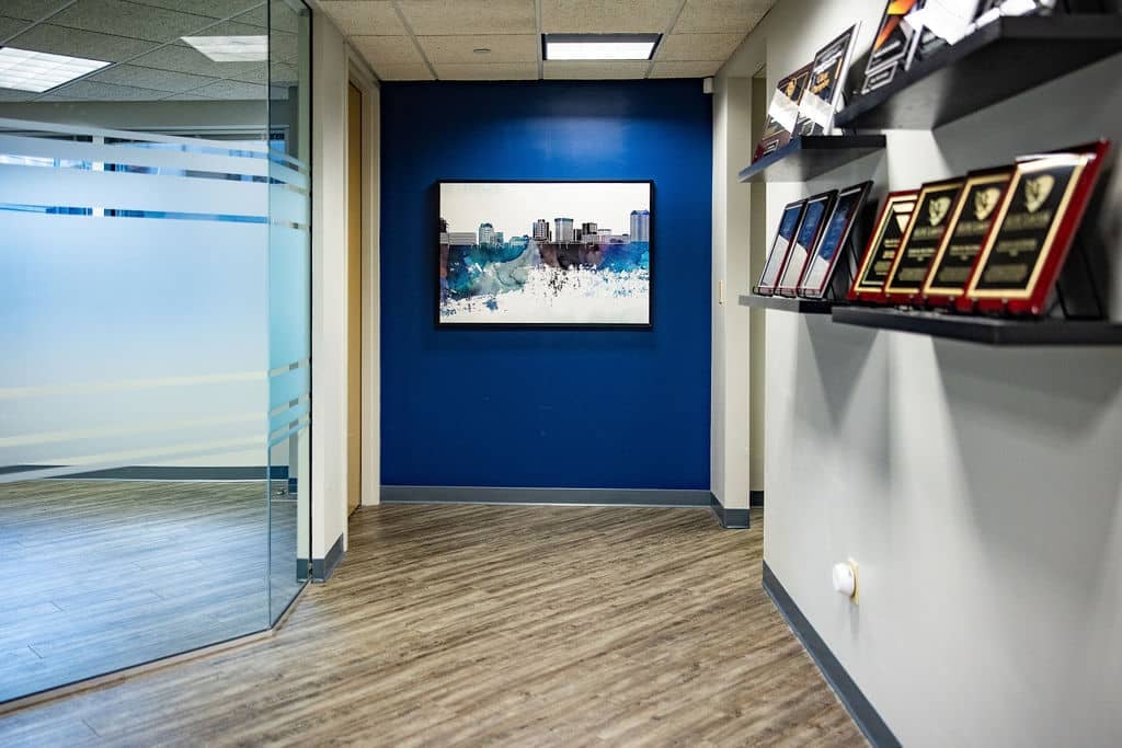 Hallway in the McCormick Law & Consulting office with framed art and award plaques