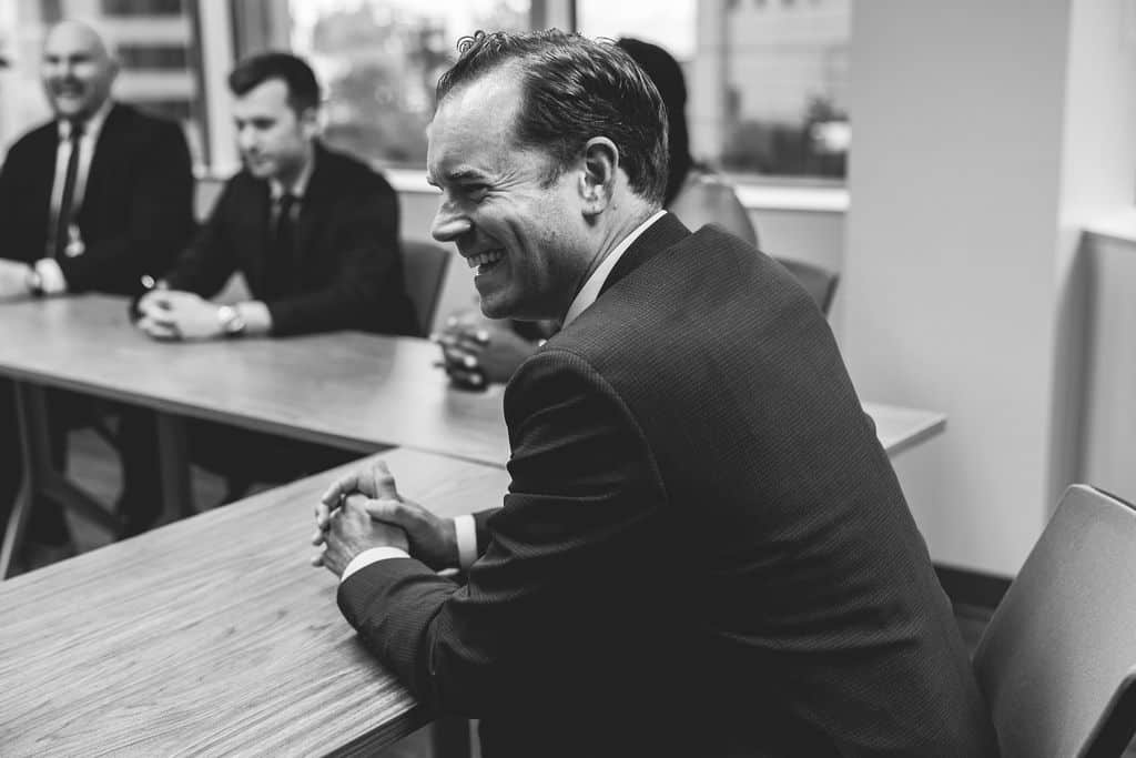 Attorneys meeting around a conference table at McCormick Law & Consulting in black and white
