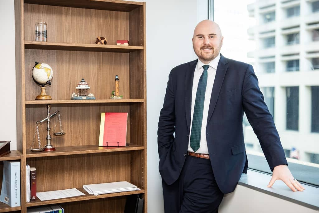 Attorney standing by a bookshelf in a McCormick Law & Consulting office